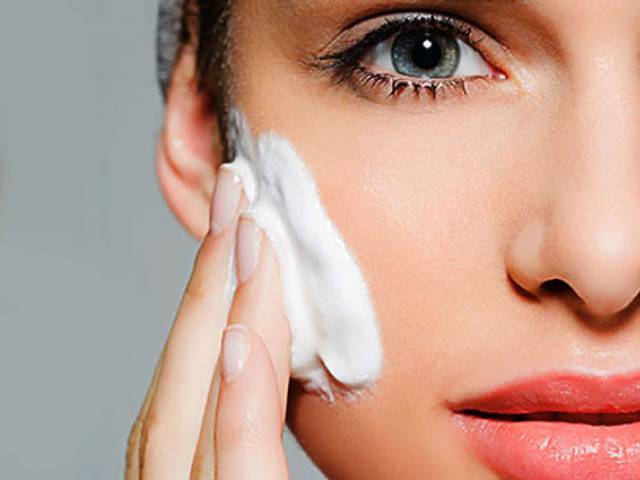 Woman applying niacinamide and retinol cream on face